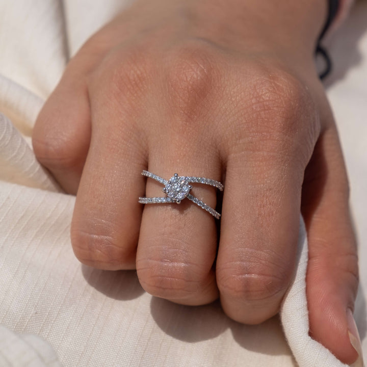 Minifora's Celestial Spark diamond ring showcased on a hand, highlighting the ring's unique design with a central cluster of lab-created diamonds forming a star-like pattern. The ring features crisscrossing pavé-set diamond bands, all set in lustrous 14K white gold. 