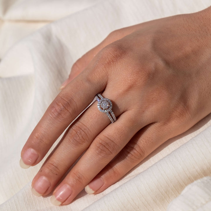 A hand showcasing Minifora's Elegant Halo Cluster Lab Diamond Engagement Ring. The design features a central cluster of lab-created diamonds, surrounded by a halo of smaller diamonds, with additional diamonds cascading down the band's shoulders in 14K white gold setting. 