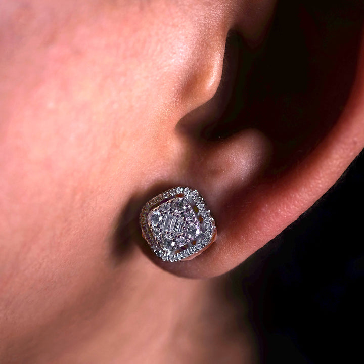 Close-up of a Minifora brand elegant stud earring featuring a radiant lab-grown cushion-cut diamond, encircled by a halo of sparkling pavé-set diamonds set in polished 14K white gold, showcased on a model's ear 