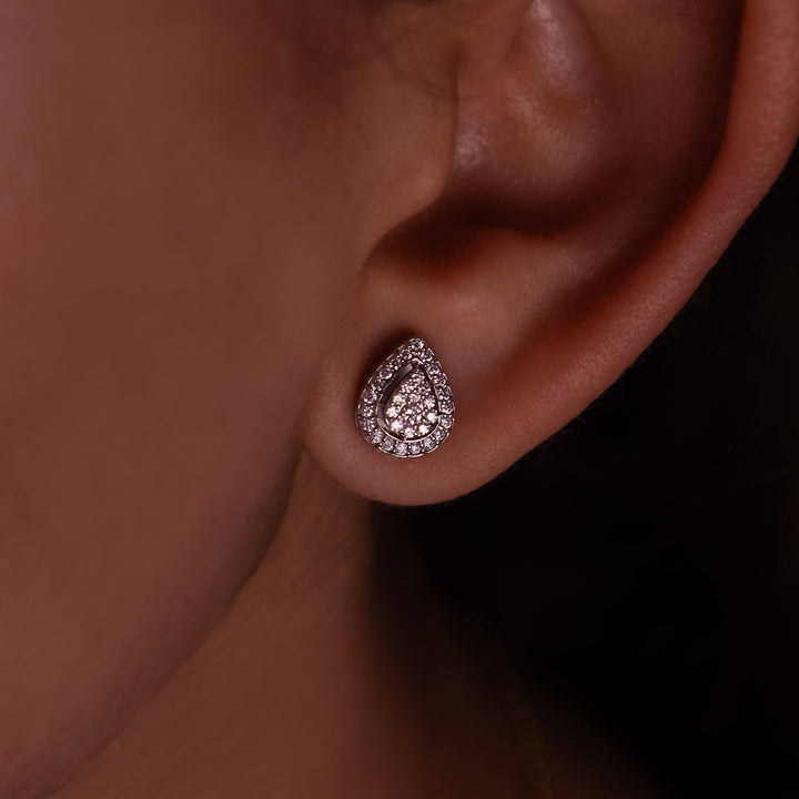 Close-up of a Minifora brand elegant stud earring featuring a radiant cluster of lab-grown diamonds in a teardrop shape in polished 14K white gold, showcased on a model's ear 