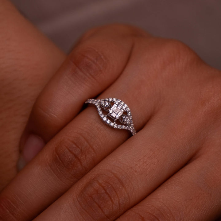 A hand adorned with a Minifora vintage-inspired ring, crafted from 14k white gold with intricately placed lab-grown diamonds. The ring boasts a unique geometric centerpiece, surrounded by a pavé setting that extends down the band.