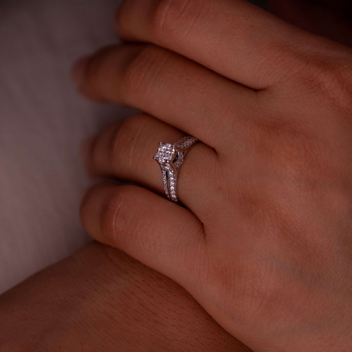 A Minifora handcrafted engagement ring, prominently displayed on a finger, exuding a sense of whispered romance with its 14k white gold band. The design features a cluster of lab-grown diamonds that resemble a blossoming flower, with diamonds continuing along the band.